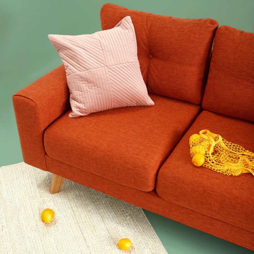 Coussin rose sur canapé orange